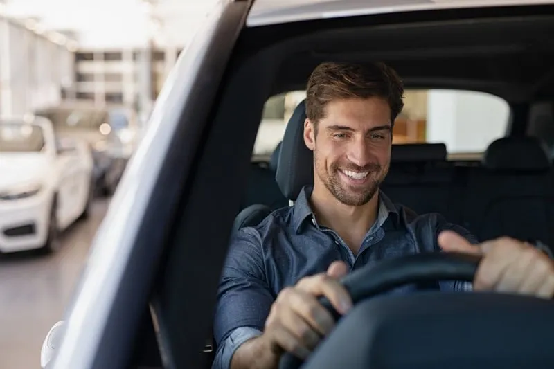 A smiling driver behind the wheel.