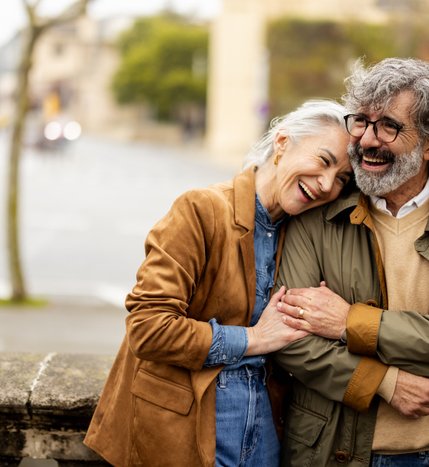A smiling couple embracing on a lakeside promenade at Georgian Shores.
